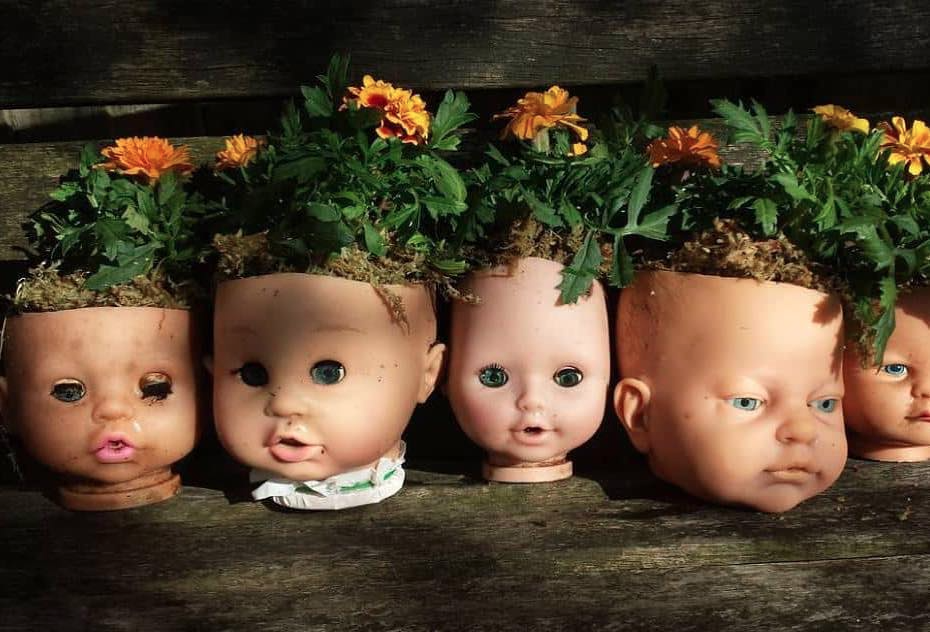 These doll head planters contain dandelions.