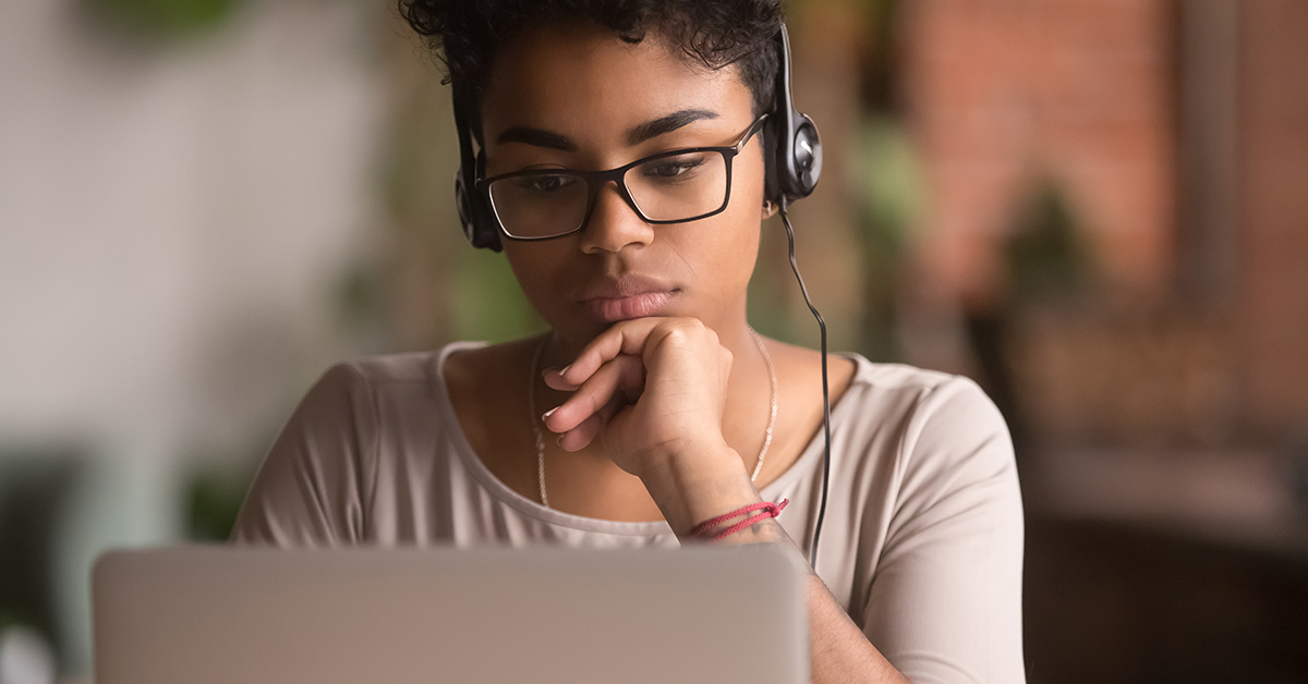 woman pondering at laptop