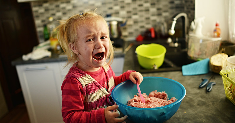 crying toddler eating a meal