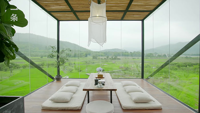 dining room with all glass walls overseeing grassy fields 
