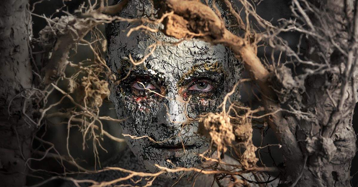 masked face hidden amongst tree branches and roots