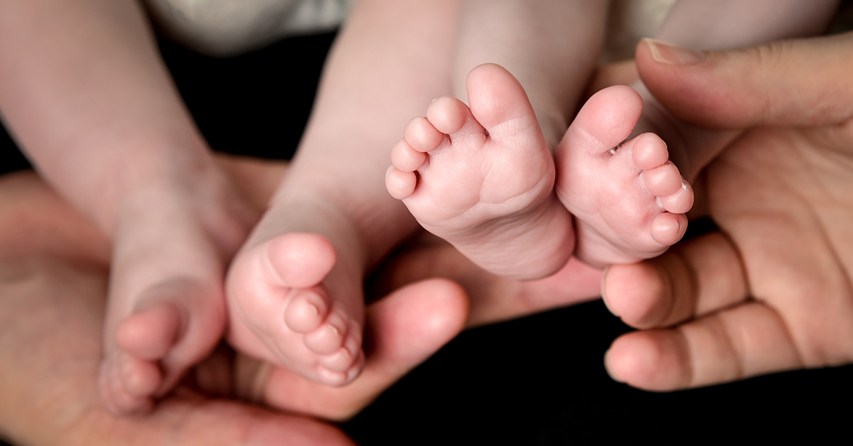 two pairs of infant feet