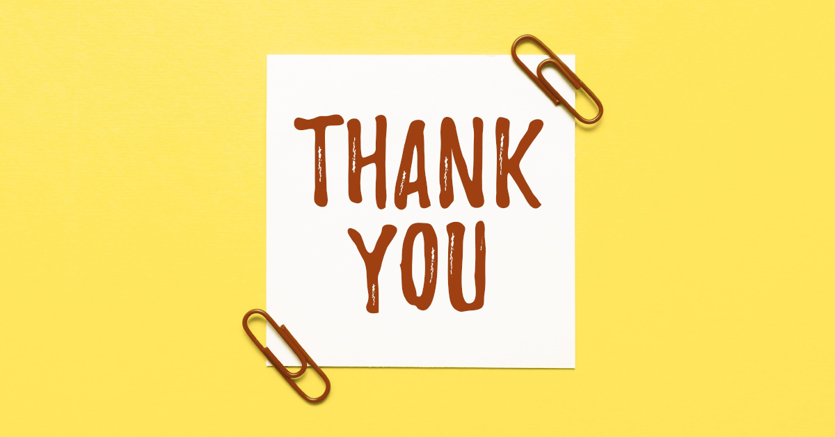 "Thank You" written on a note attached with paper clips with a yellow background