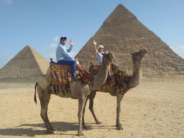 Iris Jones and Mohammed Ibriham riding camels.